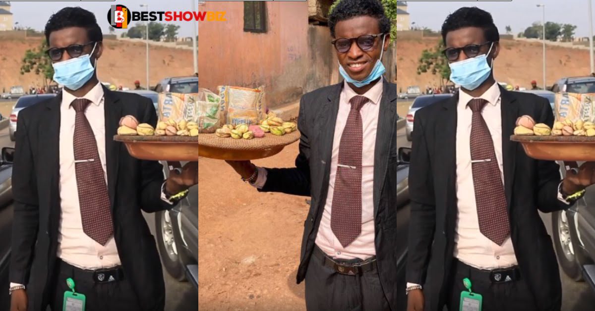 24 years old man sell Kola nut in traffic wearing a suit and tie (video)